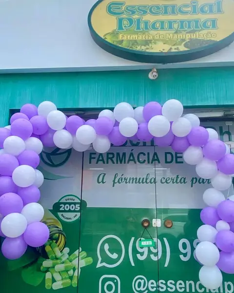 A fachada da Essencial Pharma: a placa sobre a porta, a parede verde-água e um arco de balões na entrada.